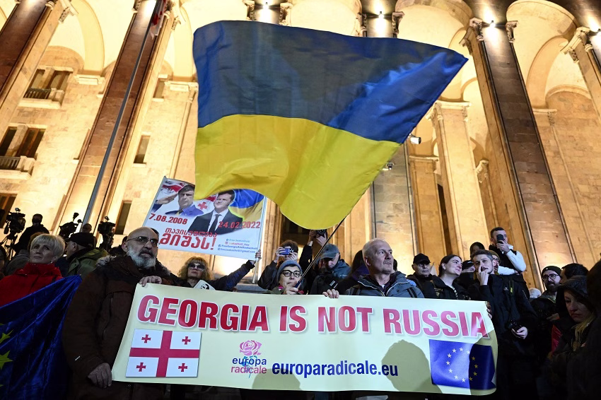 Protestanter med ukrainsk flagga och banner som lyder "Georgia is not Russia".