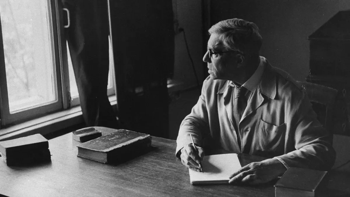 Nobelpristagaren Boris Pasternack vid ett bord, han blickar ut genom fönstret.