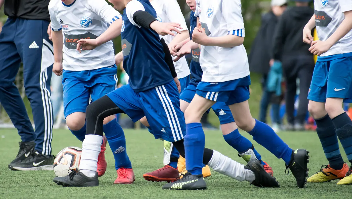 Pojkar spelar fotboll.